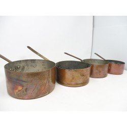Quatre anciennes casseroles en cuivre étamé avec manches en fonte vintage dans leur jus